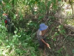 Bersama Warga Desa Babinsa Ikut Membantu Membersihkan Parit Saluran Buangan Air dari Sawah