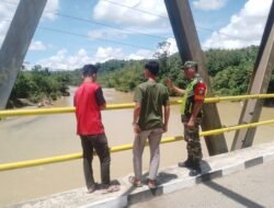 Tingkatkan Kewaspadaan terhadap Curah Hujan Tinggi Babinsa Koramil 01/Sungaimas Pantau Air Sungai di Desa Binaan
