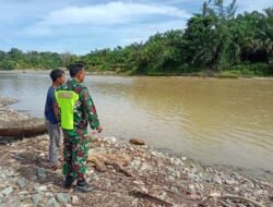 Tingkatkan Kewaspadaan terhadap Curah Hujan Tinggi Babinsa Koramil 01/Sungaimas Pantau Air Sungai di Desa Binaan