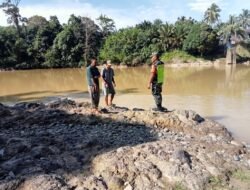 Tingkatkan Kewaspadaan terhadap Curah Hujan Tinggi Babinsa Koramil 01/Sungaimas Pantau Air Sungai di Desa Binaan