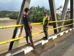 Waspada Banjir Babinsa Koramil 01/Sungaimas Memantau Debit Air Sungai di Desa Binaan