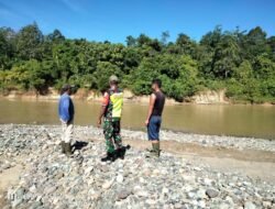 Tingkatkan Kewaspadaan terhadap Curah Hujan Tinggi Babinsa Koramil 01/Sungaimas Pantau Air Sungai Di Desa Binaan