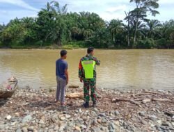 Waspada Banjir dan longsor Akibat Curah Hujan Tinggi Babinsa Koramil 01/Sungaimas Pantau Air Sungai di Desa Binaan