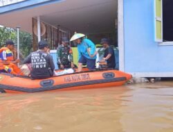 Babinsa dan Bhabinkamtibmas Evakuasi Warga Terdampak Banjir di Kombeng