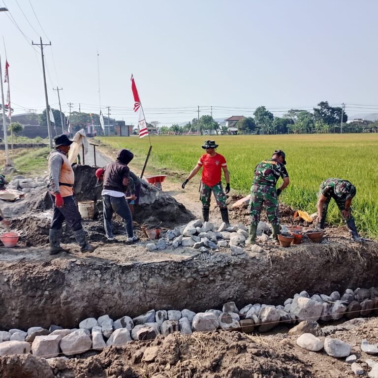 Warga dan prajurit bahu-membahu pasang buis beton